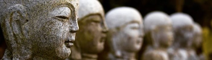 Stone Buddha statues in a row with a blurred background, capturing serenity and spirituality.